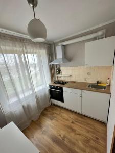 a kitchen with white cabinets and a sink and a window at Sea side apartments in Jūrmala