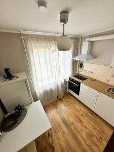 Sea side apartments في يورمالا: مطبخ بدولاب بيضاء وقمة بيضاء