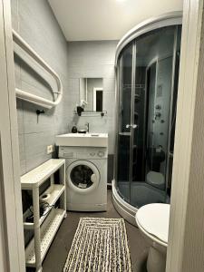 a bathroom with a washing machine and a shower at Sea side apartments in Jūrmala