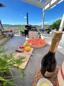 - une table avec une bouteille de vin et une pizza dans l'établissement Summer cabin by the sea Holmsbu. (40 min from Oslo), à Asker