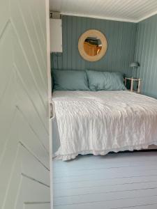 um quarto com uma cama e um espelho na parede em Summer cabin by the sea Holmsbu. (40 min from Oslo) em Asker