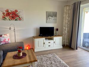 a living room with a tv on a white cabinet at 3001 - Grömitz in Grömitz