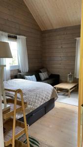 um quarto com uma cama e um sofá em Summer cabin by the sea Holmsbu. (40 min from Oslo) em Asker