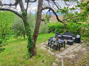 uma mesa e cadeiras sentadas ao lado de uma árvore em Casina Gentili em Perugia