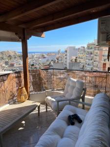 a balcony with two chairs and a view of a city at DreamCatcher /ρετιρέ με θέα θάλασσα in Athens