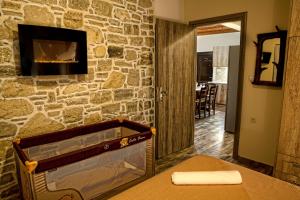 a room with a stone wall with a fireplace at Villa Gamma Kreta in Kamilari +24 photos