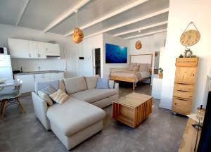 a living room with a white couch and a kitchen at Ático en Las Canteras in Las Palmas de Gran Canaria