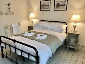 um quarto com 2 camas com toalhas e 2 candeeiros em Delightful Seaside Binnacle Cottage -hosted by Whitstable-Holidays em Whitstable