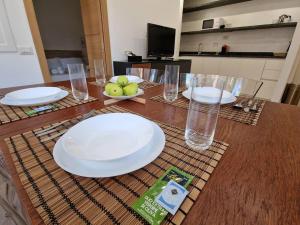 a wooden table with white plates and glasses on it at Casa Camilla in Rome