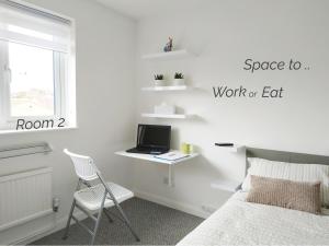 a bedroom with a bed and a desk with a laptop at Town House Chantry - With Self Check In and Free Parking - Rooms at ipswichdigs in Ipswich