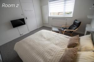 a bedroom with a bed and a chair and a window at Town House Chantry - With Self Check In and Free Parking - Rooms at ipswichdigs in Ipswich