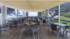 a restaurant with tables and chairs on a deck at Hostal Etxeberri in Eugi