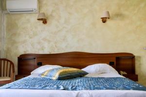 - une chambre avec un lit et une tête de lit en bois dans l'établissement Anglade Hotel, au Lavandou