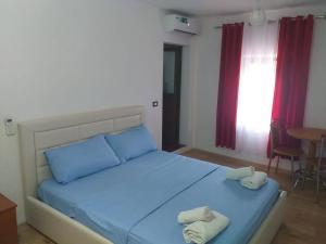 a bedroom with a blue bed with two towels on it at Kulla e Vjeter (Bar Restaurant, Guesthouse, Parking and Camping) in Koman