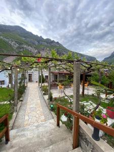 een tuin met een stenen loopbrug voor een gebouw bij Kulla e Vjeter (Bar Restaurant, Guesthouse, Parking and Camping) in Koman