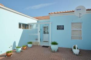 a white house with potted plants in front of it at Family Tides in Yzerfontein