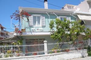 a green house with a white fence in front of it at Nonna in Lefkada