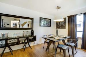 a dining room with a table and chairs and a mirror at Contemporary Dallas Condo with Pool Access! in Dallas