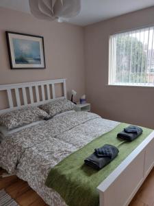 a bedroom with a bed with two towels on it at Cosy one bed apartment in Carnlough in Ballymena