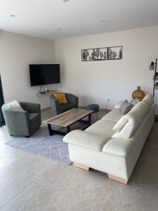 salon z białą kanapą i 2 krzesłami w obiekcie Charmant chalet, spacieux, proche du lac, vue sur la montagne w mieście Gérardmer