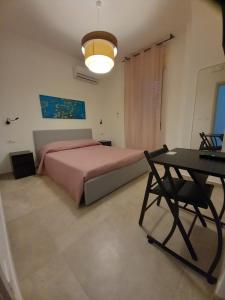 een slaapkamer met een groot bed en een tafel bij Neapolis Apartment & Rooms in Siracusa