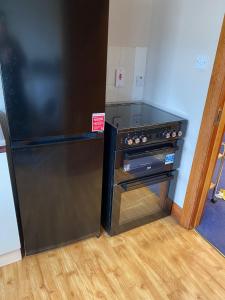 a kitchen with a black stove and a refrigerator at Lovely 3 bedroom apartment in Buncrana in Buncrana