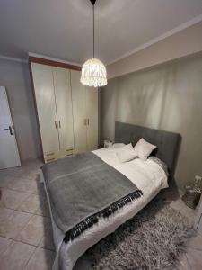 Un dormitorio con una cama grande y una lámpara de araña. en DreamCatcher /ρετιρέ με θέα θάλασσα en Athens