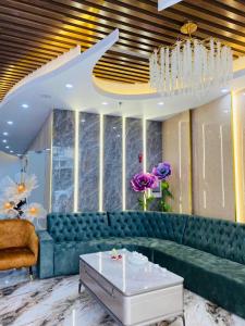 a living room with a green couch and a table at Thanh Cong Hotel Ha Long in Ha Long