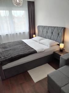 una camera con un grande letto e un divano di Apartman 007 a Kragujevac