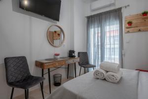 um quarto com uma cama, uma secretária e um espelho em Mamo Thessaloniki Studios em Tessalônica