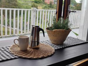 a table with a coffee mug and a plant on a porch at Apartamento nuevo con vistas a las Islas Cíes in Cangas de Morrazo +16 photos