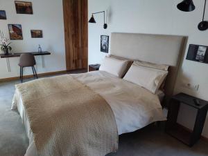 a bedroom with a large bed and a table at Apartamento nuevo con vistas a las Islas Cíes in Cangas de Morrazo