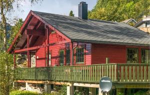 una casa roja con un porche y un cartel delante de él en Fyksesund, en Steinstø