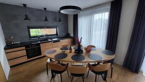 una sala da pranzo con tavolo, sedie e TV di Chalet Prestige a Valča