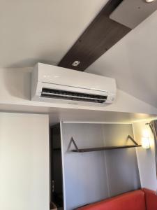 a white air conditioner on the ceiling of a room at Mobil home Clim, Tv - Camping Vic-la-Gardiole 4 etoiles - 006 in Vic-la-Gardiole