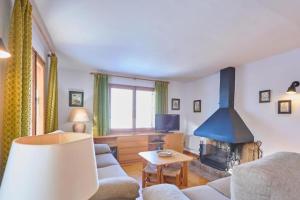 a living room with a couch and a fireplace at Casa l'Avet. El Vilar d'Urtx in Escardacs