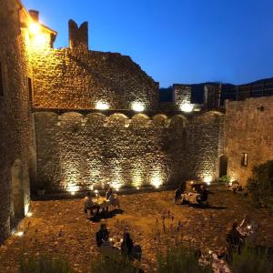 une cour d'un château éclairée la nuit dans l'établissement TENUTA CASTEL DELL'AQUILA, à Gragnola