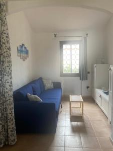 sala de estar con sofá azul y ventana en Residence La Conia, en Cannigione