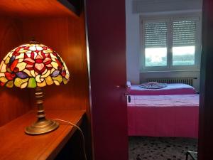 lámpara en un tocador en un dormitorio con cama en B&B delle Arti en Crema