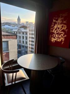 einen Tisch und Stühle in einem Zimmer mit Fenster in der Unterkunft Root Karaköy in Istanbul