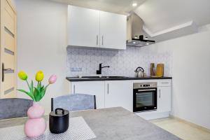 a kitchen with a table with a vase of flowers at Apartament na wzgórzu in Muszyna