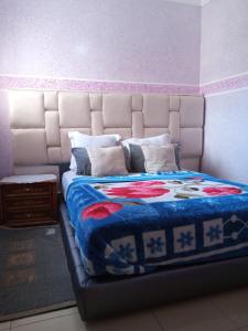 伊夫兰Groupe d'appartements Salwa的一张带蓝色毯子和枕头的床