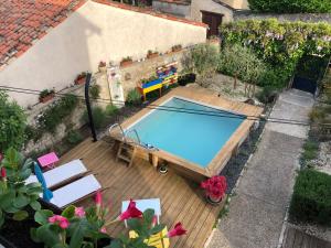 uma vista sobre uma piscina num deque de madeira em Saint James House em Pons