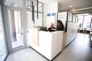 a man and a woman sitting at a counter with a laptop at White Luxury in Thessaloniki