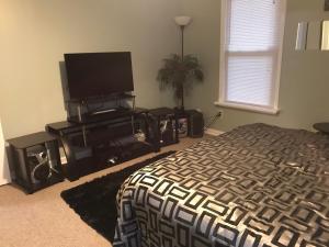 a bedroom with a bed and a flat screen tv at Your Getaway Home / Finished Basement Private Entry in Palmetto