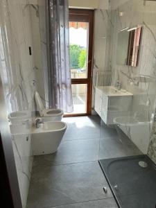 Baño blanco con 2 lavabos y aseo en Appartamento Mesi, en Conegliano