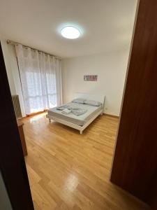 una camera con letto e pavimento in legno di Appartamento Mesi a Conegliano