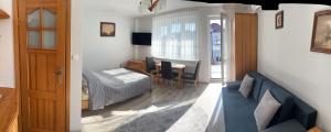 a living room with a bed and a dining room at Szyper in Jastarnia