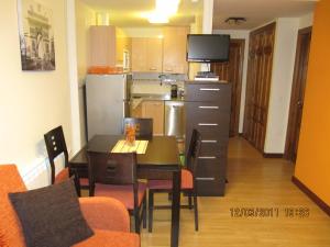 a kitchen with a dining room table and a television at Apartamentos Reservas León in San Isidro