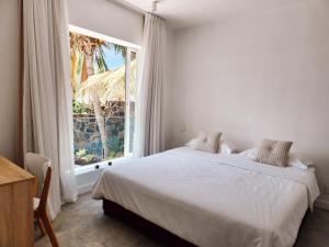 a bedroom with a bed and a large window at Cozy pavillon with private jacuzzi on rooftop terrace - Jolly's Rock in Grand Gaube